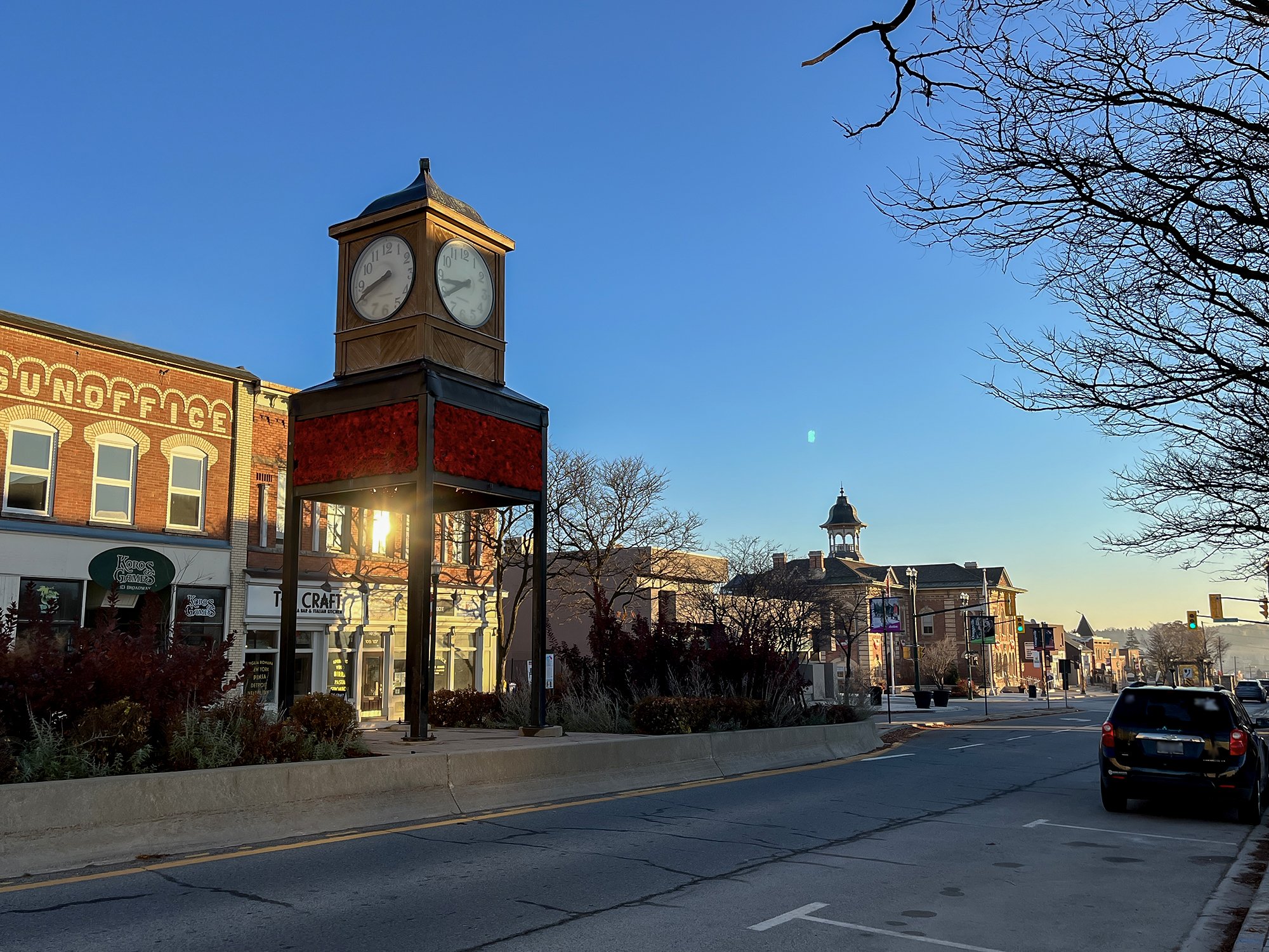 The clock tower in downtown Orangeville with poppies wrapped around it.